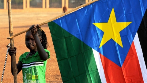 A young girl hangs the South Sudan flag