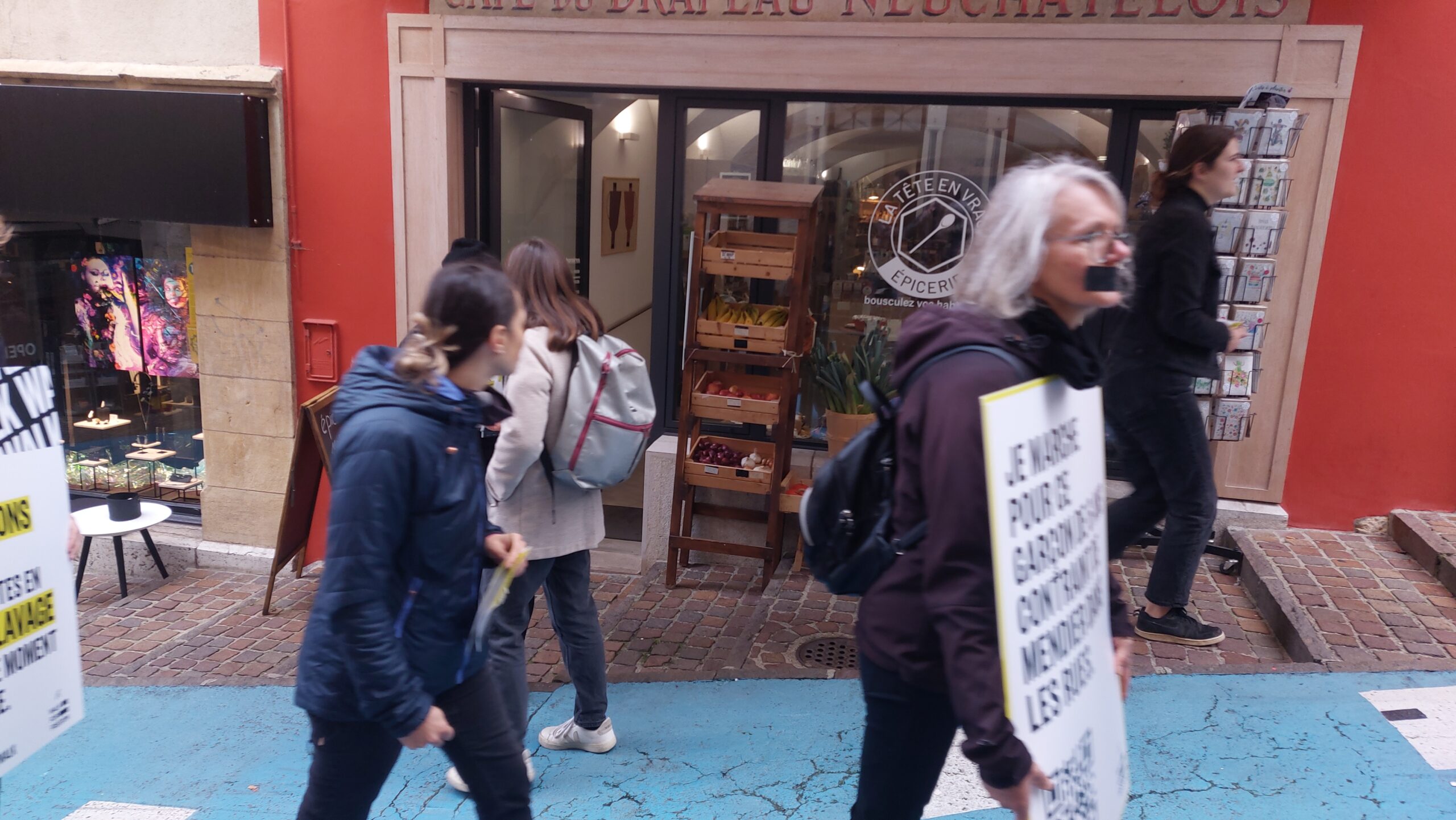 Des manifestants défilent devant une boutique de Neuchâtel.