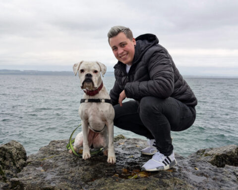 Flora Barbieri et sa chienne Ghyna sur un rocher au bord du lac de Neuchâtel