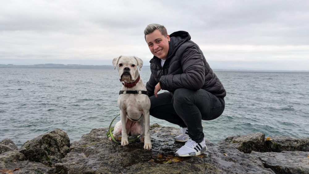 Flora Barbieri et sa chienne Ghyna sur un rocher au bord du lac de Neuchâtel