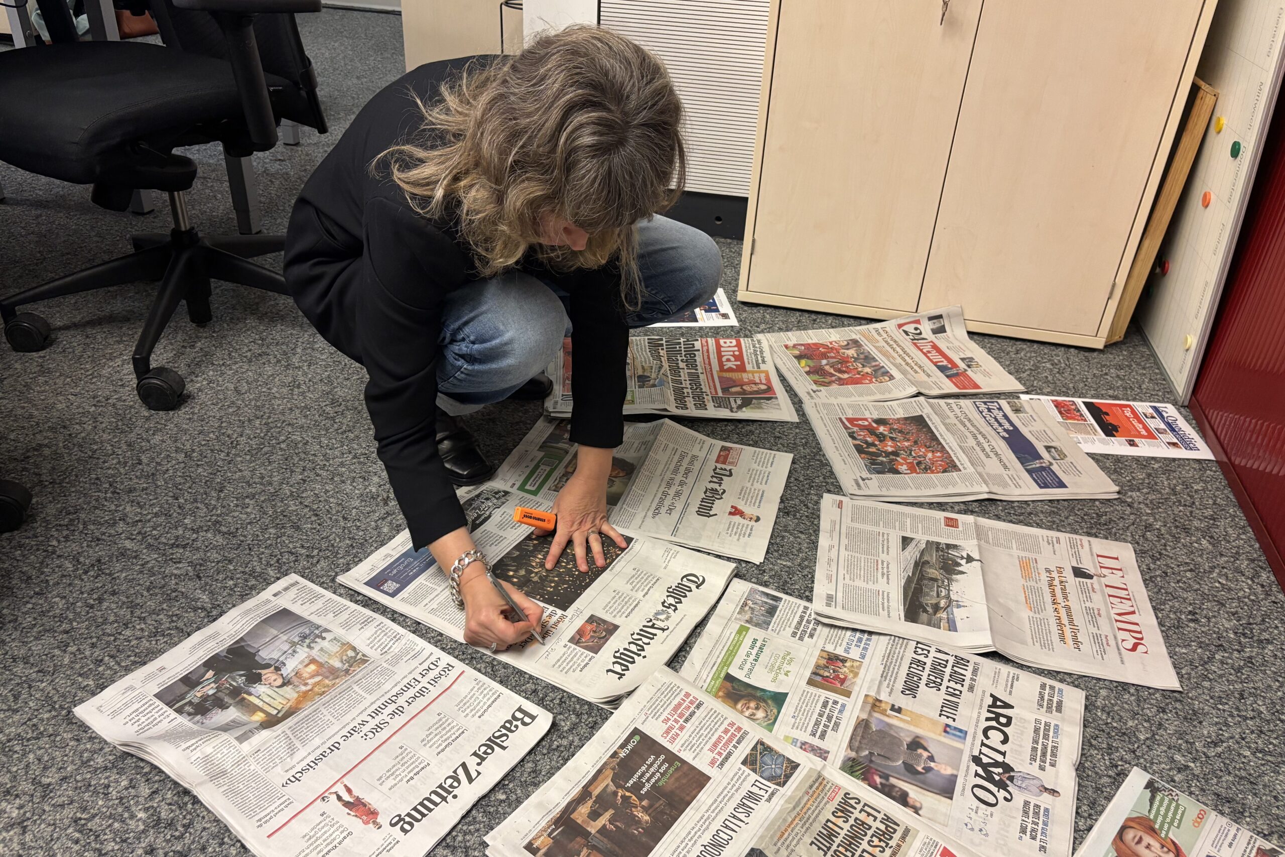 Valérie Droux prépare sa Revue des Unes en posant les journaux parterre